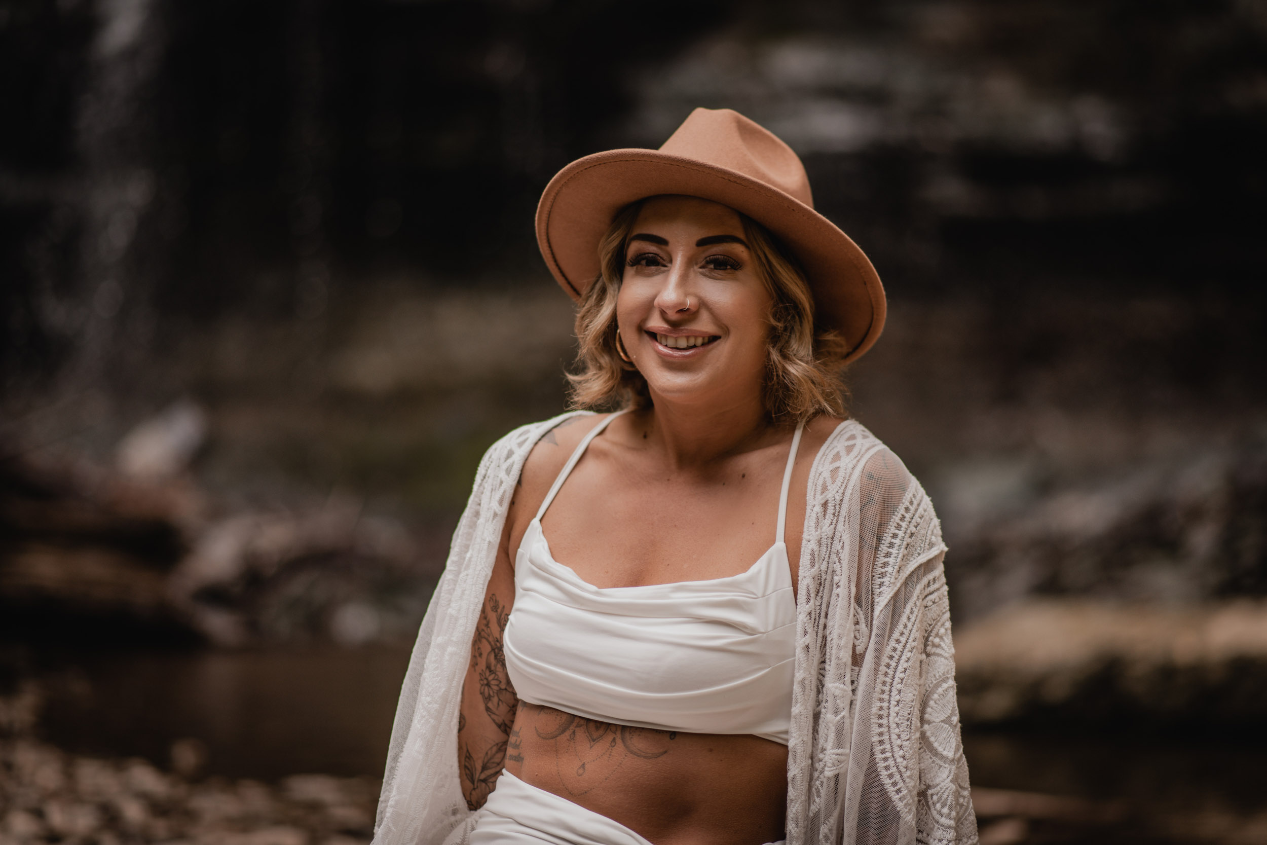woman smiling in front of waterfall